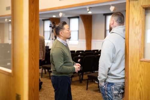 Photo of two men talking at the conclusion of a church service
